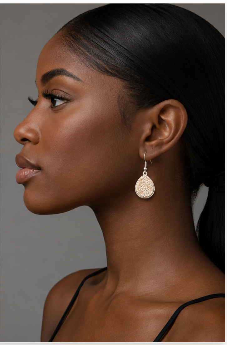 Woman wearing a gold earring against a neutral background