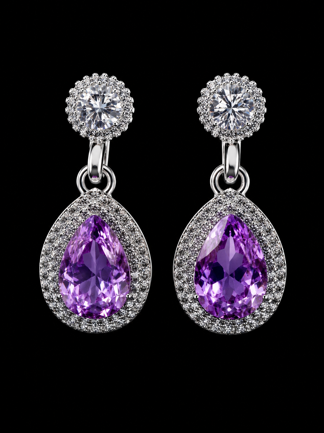 Pair of earrings with purple teardrop stones and silver accents on a black background