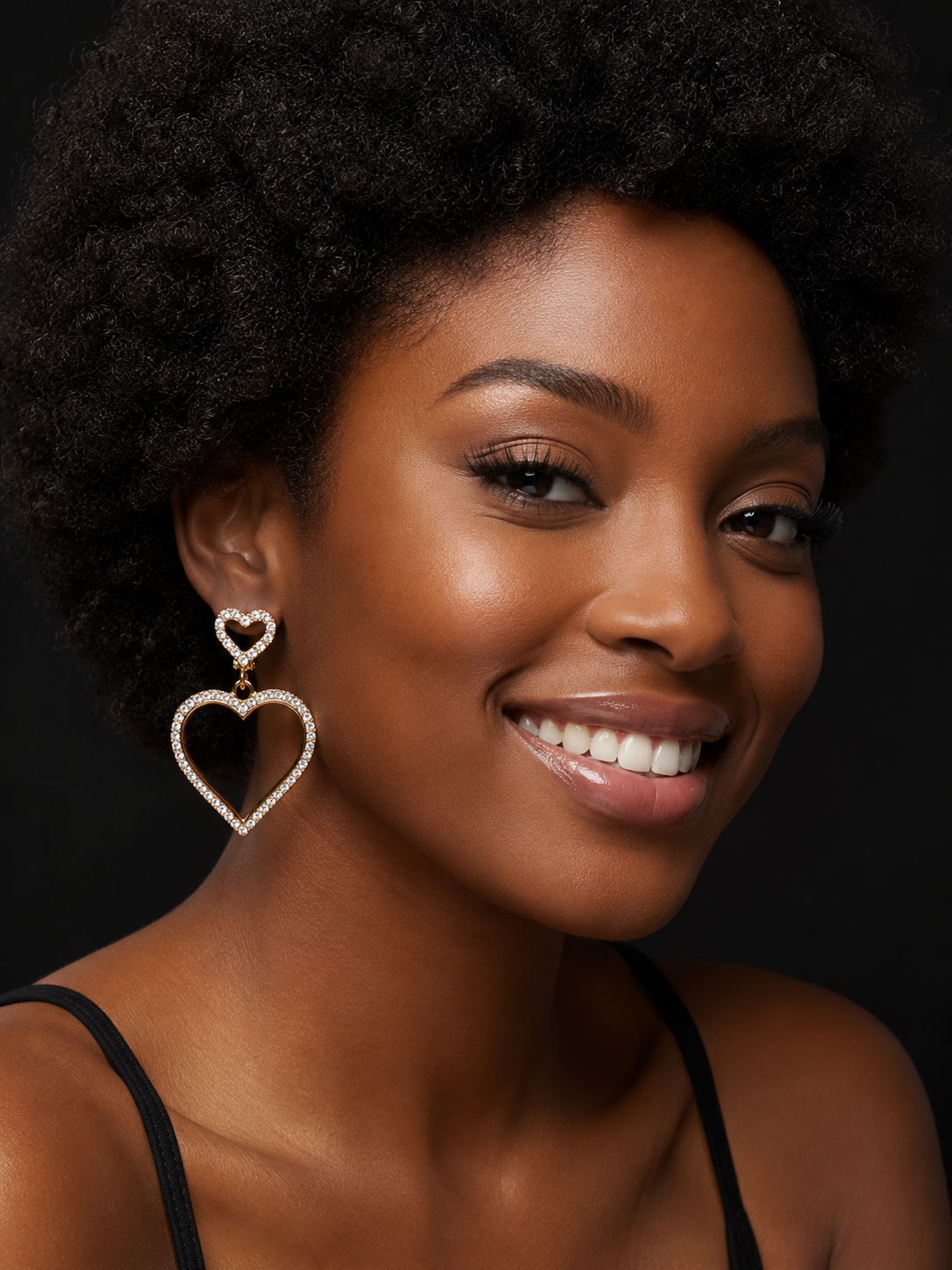 Woman wearing heart-shaped earrings against a dark background